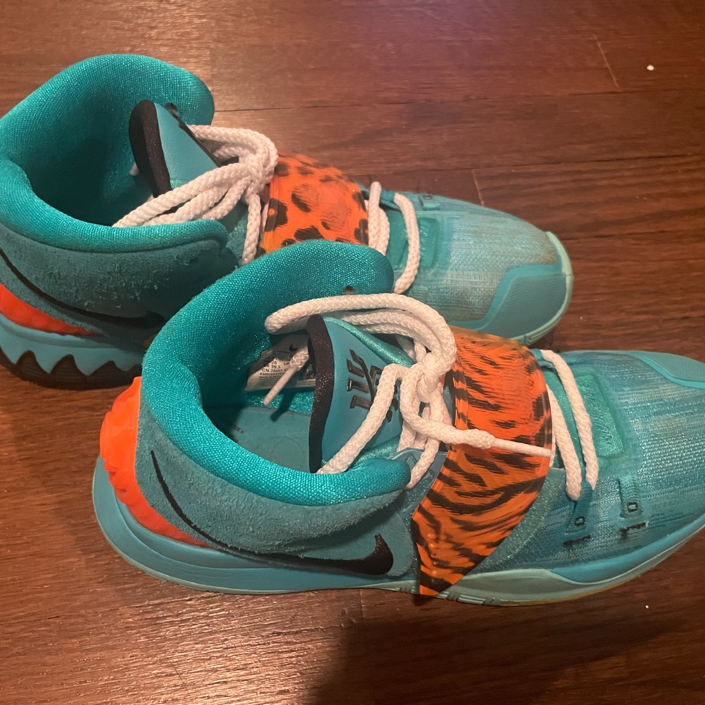 Gently used Kyrie Irving Men’s sneakers in teal and zebra print.